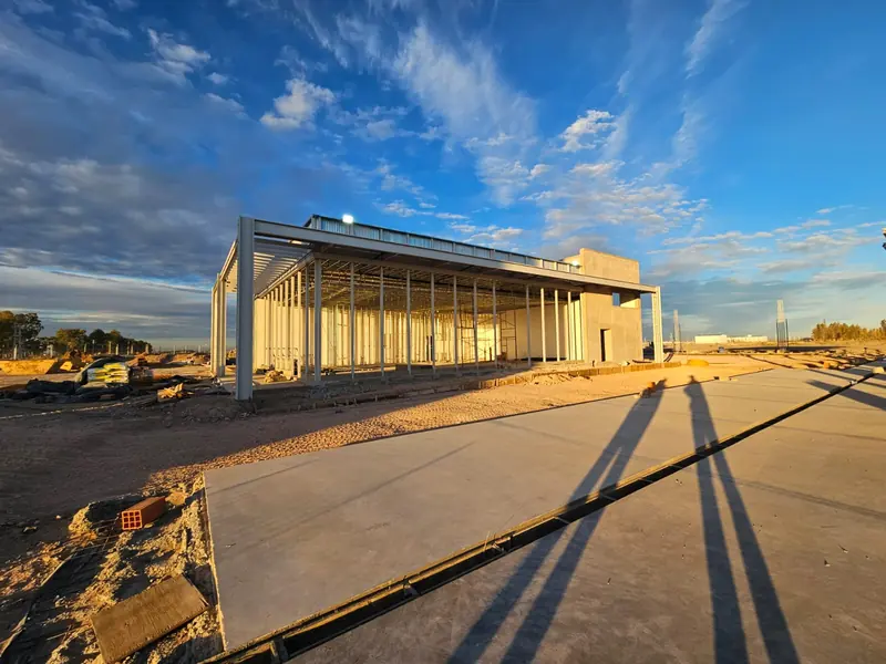 Steel structure of the shop at dusk with the concrete pavement completed