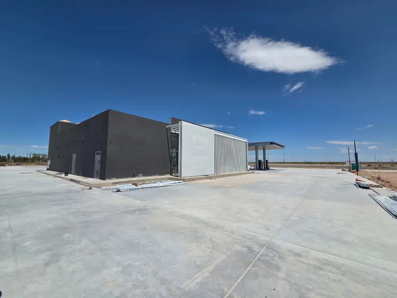 Completed volumes of the shop and services area on the concrete forecourt