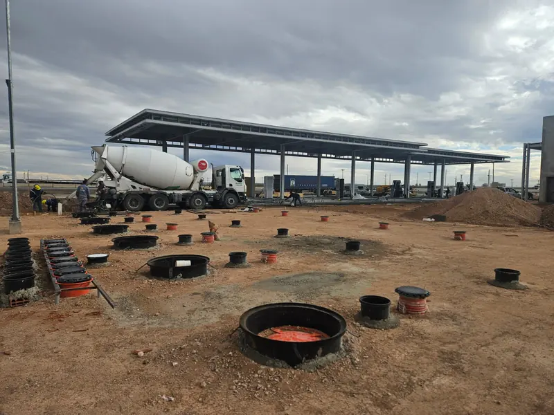 Concrete mixer truck next to the pump island footings with the canopy in the background