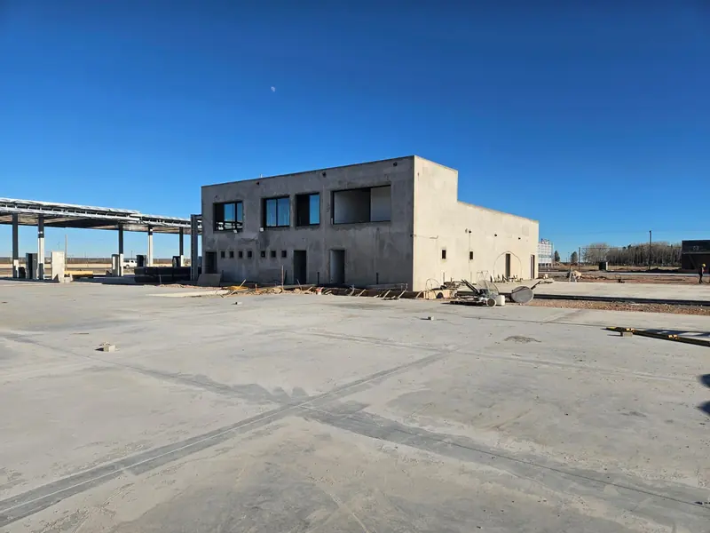 Completed two-storey exposed concrete building and paved forecourt