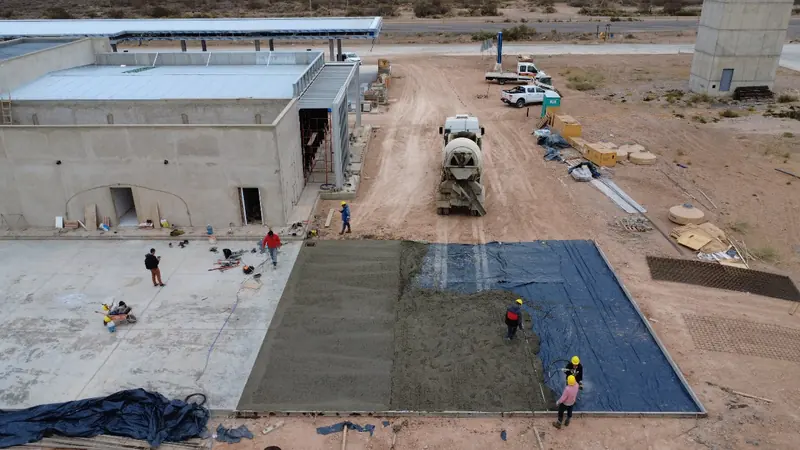 Crew pouring the concrete pavement next to the station building