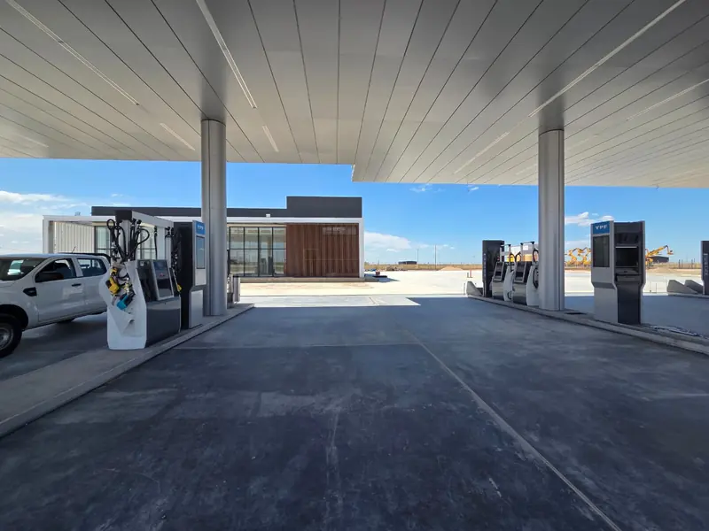 View under the canopy with the pumps installed and the shop in the background
